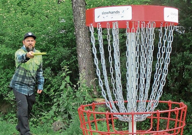 Benji Fischer beim Abwurf. Die Ketten halten den Flug der Disc-Golf-Scheibe auf und diese fällt in den darunter liegenden Korb, das Ziel. (Bild Nepita Santiago)
