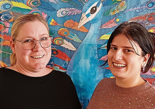 Martina Lack, Schulsozialarbeiterin in Aeugst (links), und Sheyda Shahnazari, Schulsozialarbeiterin in Wettswil, vor einem Gemeinschaftswerk, zu dem an der Schule Aeugst jedes Kind eine Feder beitrug. (Bild Regula Zellweger)