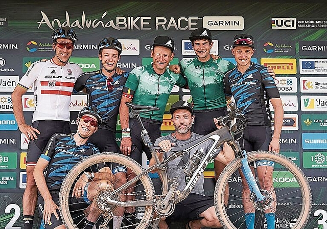 Urs Huber (Bildmitte, stehend) und Simon Schneller (rechts von Huber) lachen umringt von ihrem Teamkollegen als Sieger vom Podium des Andalucia Bike Race. (Bild Sportograf)
