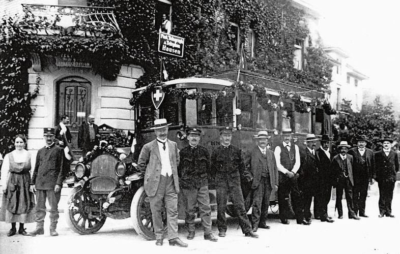 Am 1. Juli 1920 wurde ein langersehnter Traum wahr: Endlich konnte die erste Postautolinie mit drei auf ehemaligen Armeelastwagen aufgebauten Omnibussen eingeweiht werden. Die örtliche Prominenz hat sich in Hausen vor der Post versammelt. Von nun an verkehrten täglich drei Kurse zwischen Sihlbrugg und Bremgarten. (Bild Archiv Gemeinde Hausen)