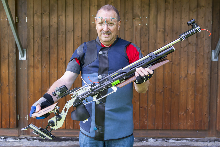 Christian Hosig in voller Ausrüstung: Mit Schiessbrille, Schiessjacke, Schiesshandschuhen und Luftgewehr, das für den Laien kaum mehr als solches erkennbar ist.